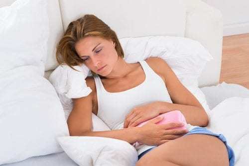 Woman With Hot Water Bag In Bed
