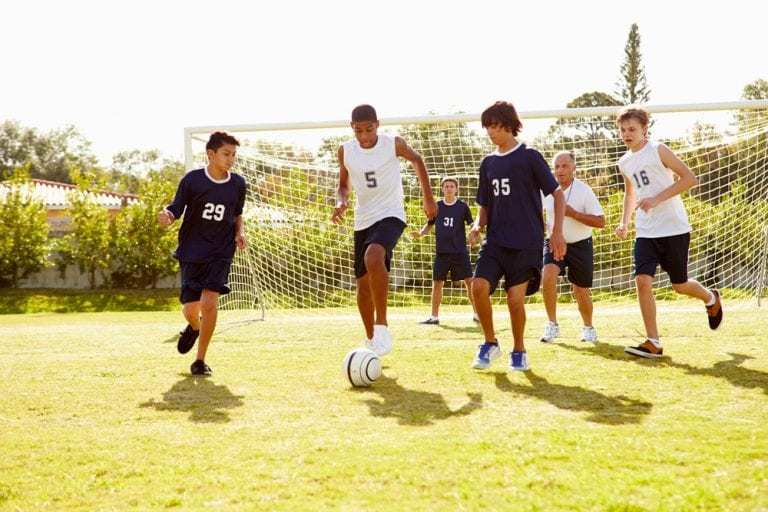 Boys' High School Soccer team playing on field